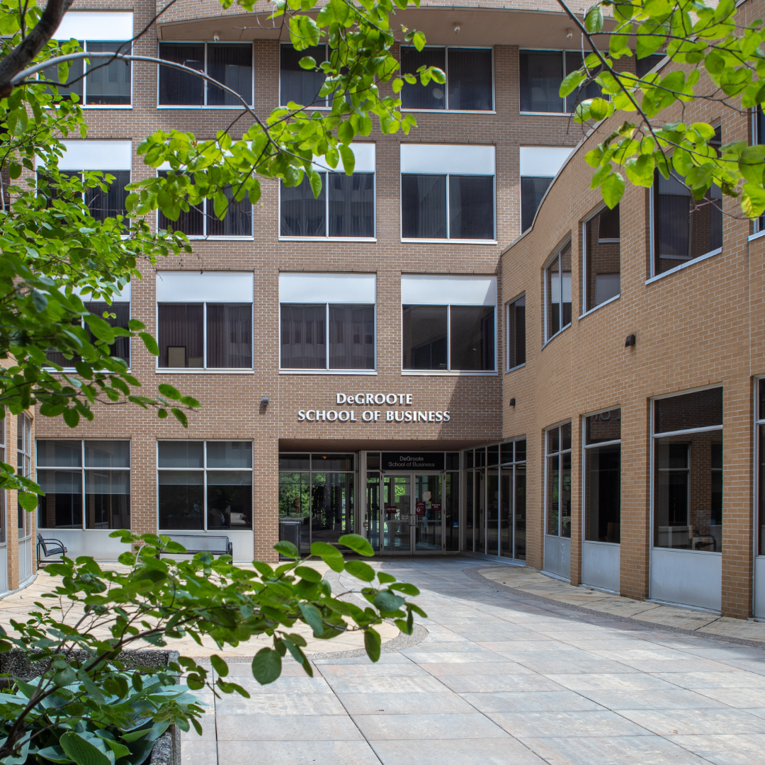 DeGroote School of Business building featuring a facade with multiple windows. Trees in front obscure some view.