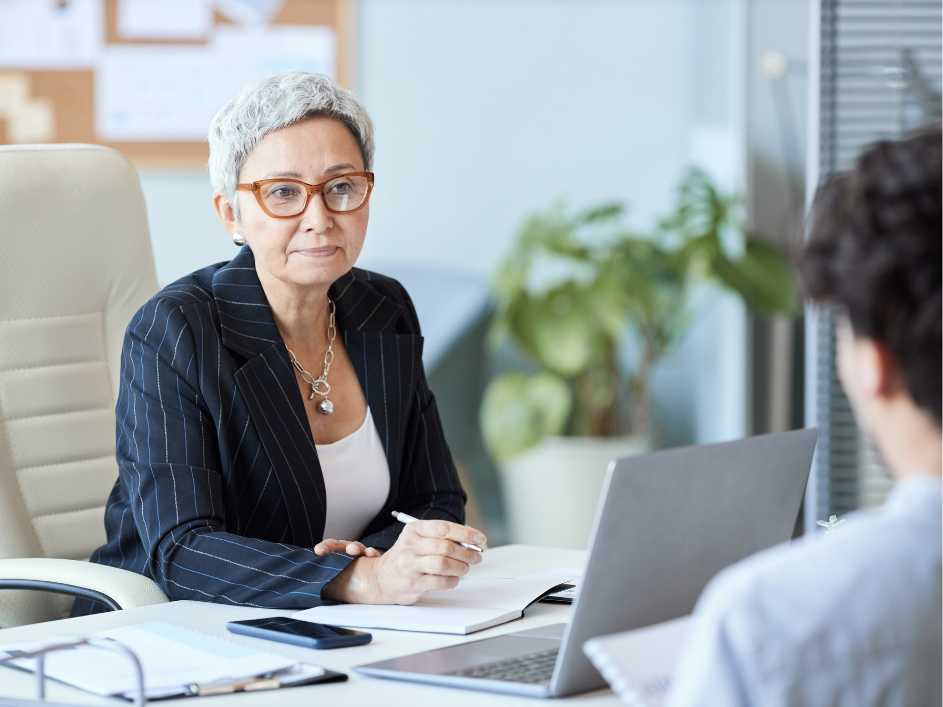 Female professional in business attire conversing with male colleague. Ideal for HR and Management research.