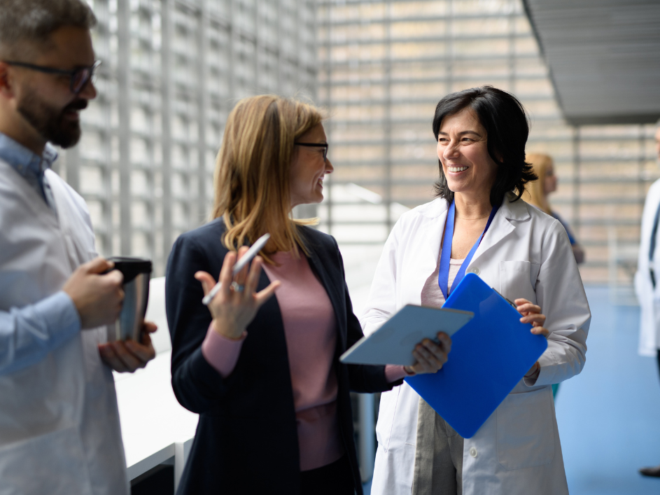 Health Policy and Management researchers and board members in casual conversation in a hospital setting.