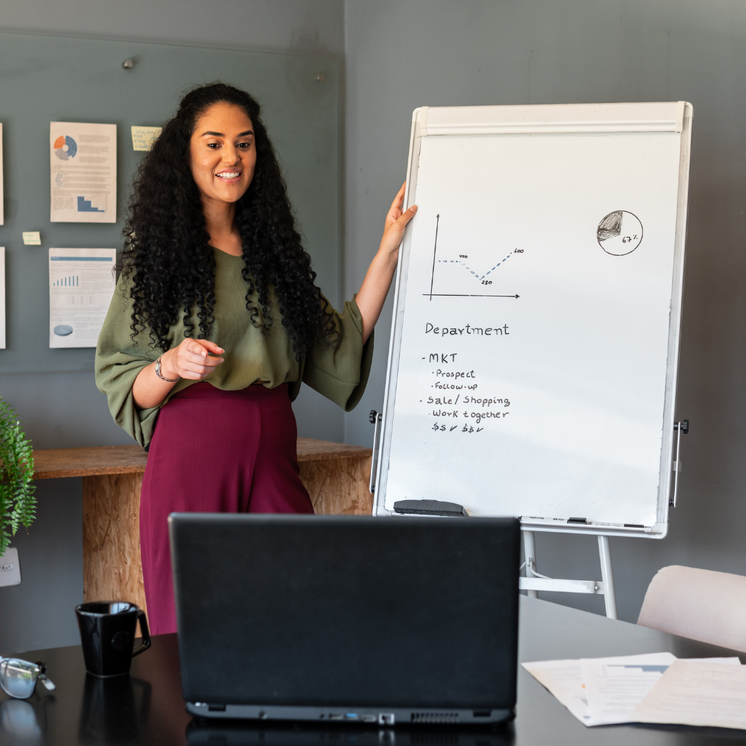 A female researcher with curly hair, presenting research at DeGroote.