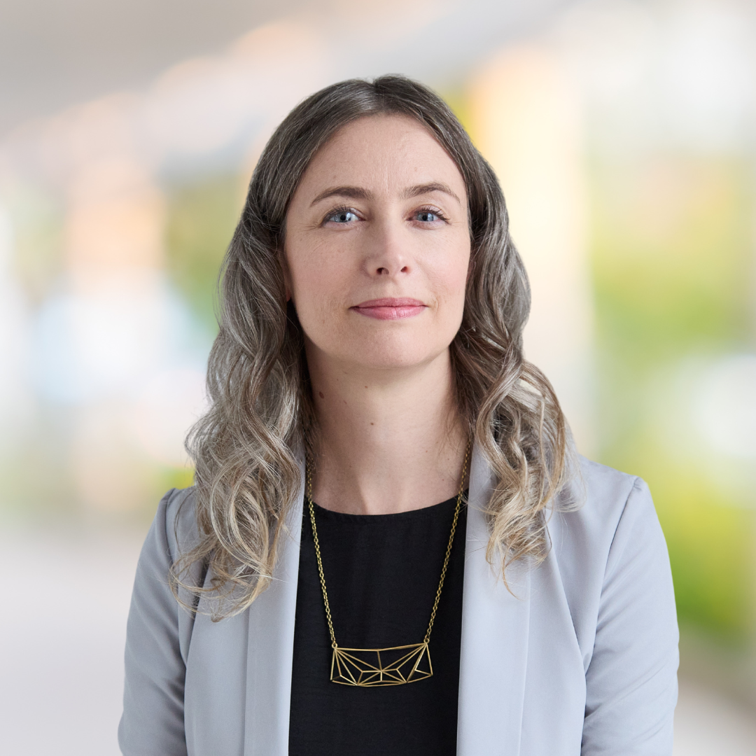 Headshot of Catherine Connelly, a smiling woman wearing a light grey blazer.