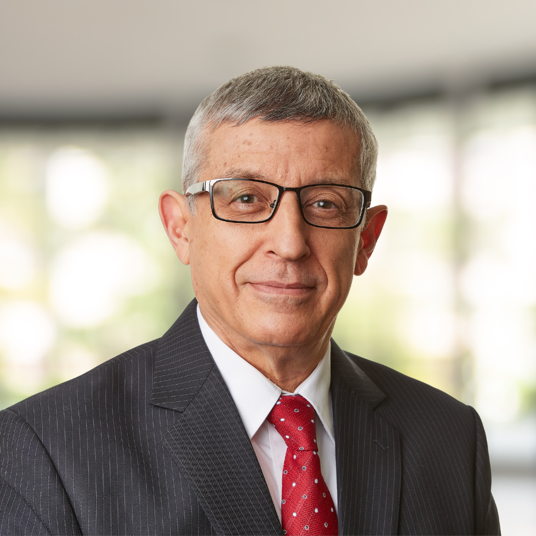 Headshot of Mahmut Parlar, a smiling man wearing glasses and a dark suit.