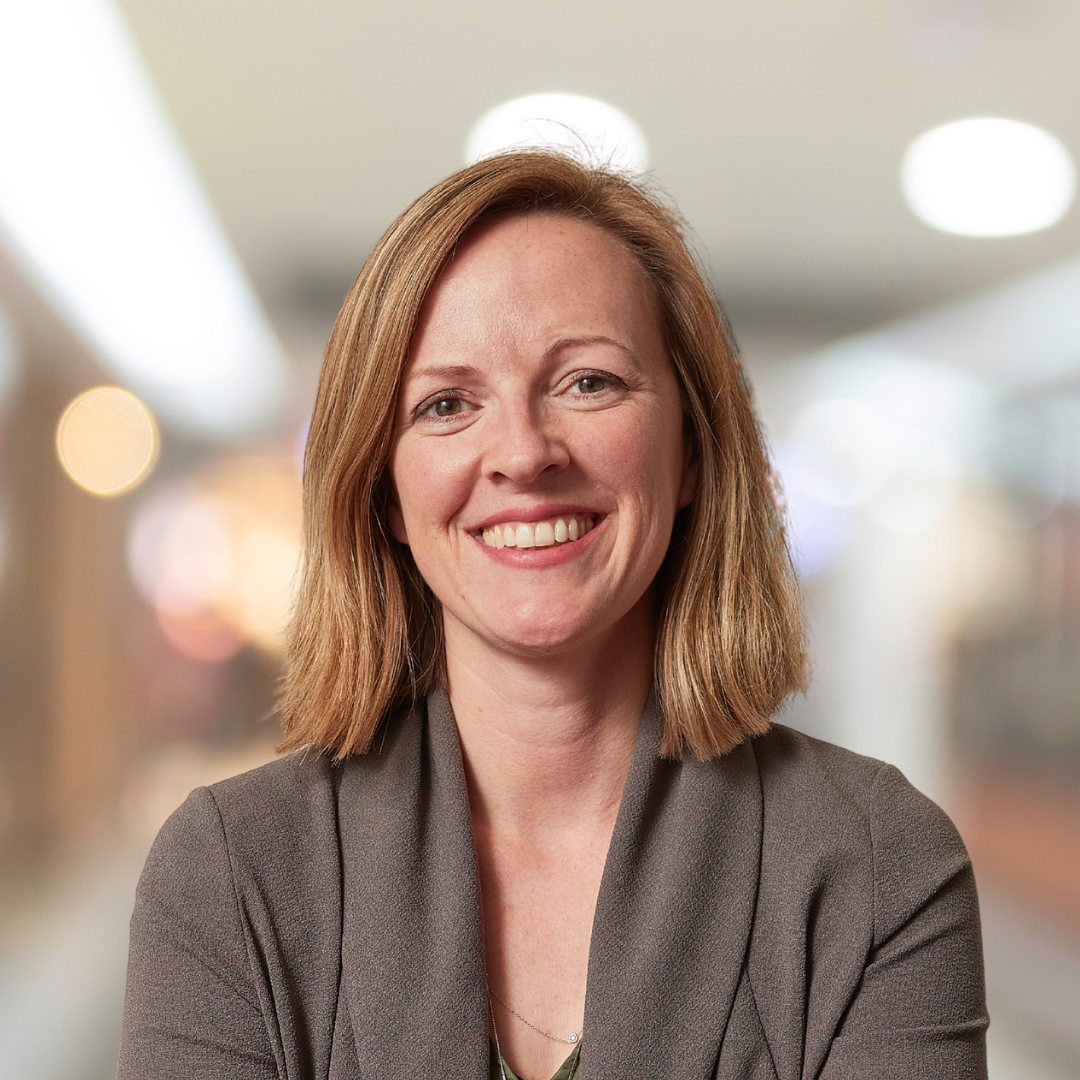 Headshot of Erin Reid, a smiling woman wearing a light brown blouse.